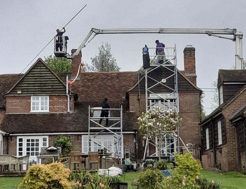 The Roof Moss Cleaners using cherry picker and scaffolding to clean roof safely and professionally in St Neots, Cambridgeshire
